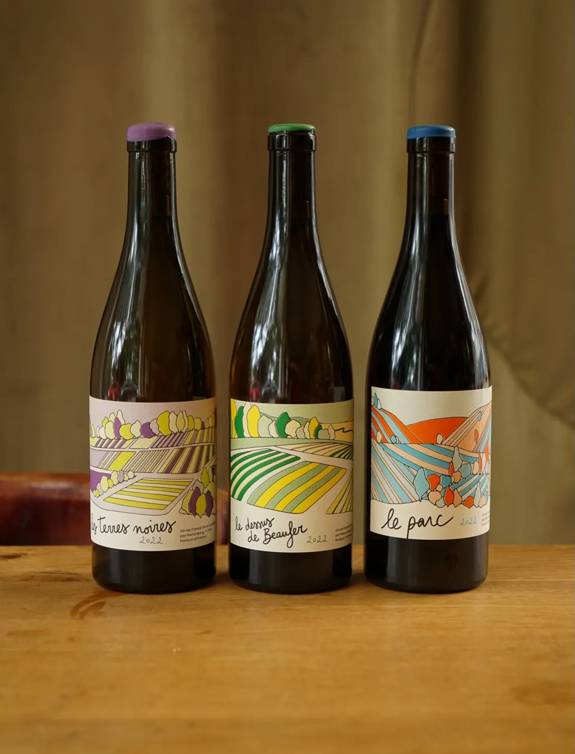 three bottles of natural wine with colourful labels