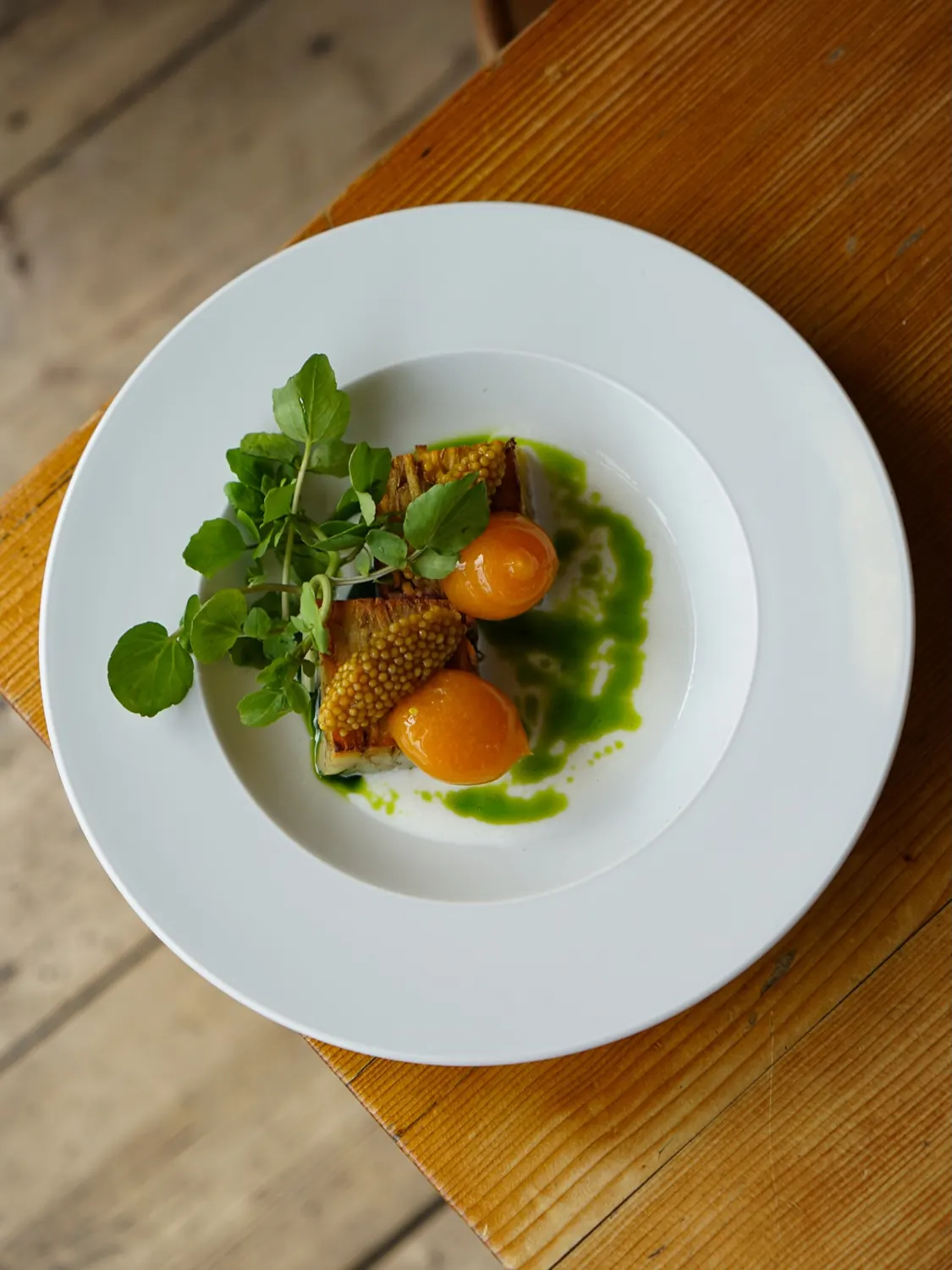 a plate with watercress and orange accents