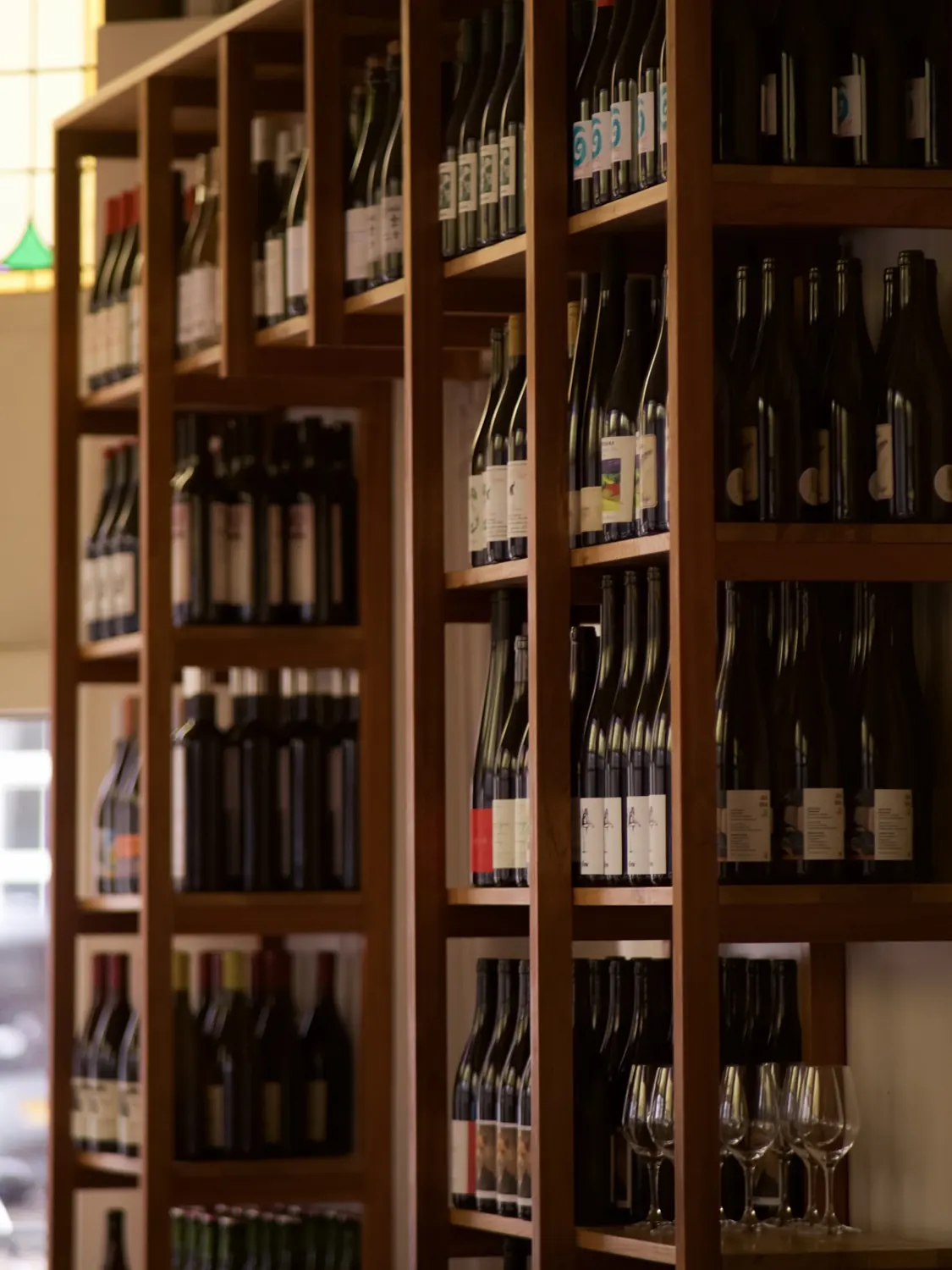 wooden shelves full of natural wine bottles